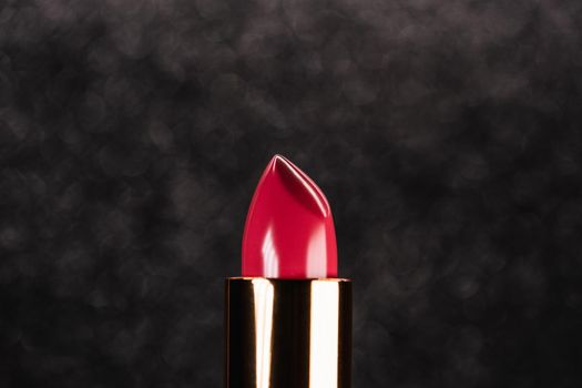 Red lipstick on black dark background. Showcase or advertisement for beauty brand, Concept of fashion, cosmetics. High quality