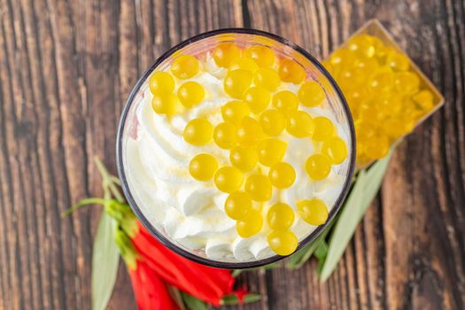 Banana, strawberry and pineapple smoothie on wooden table and bubble tea or boba tea balls on it