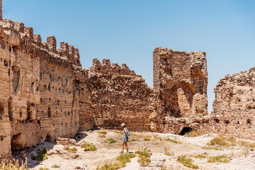 Tourist visiting the walls of a medieval castle in the sun. Almonacid Castle, in Spain