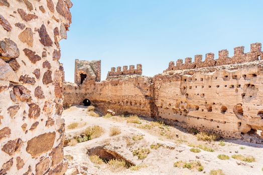 Ancient stone walls of a restored medieval castle in a sunny day. Almonacid Castle in Spain