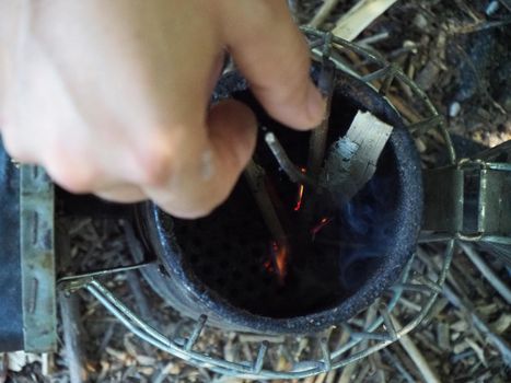 starting a bee smoker before harvesting honey hives in the farm.