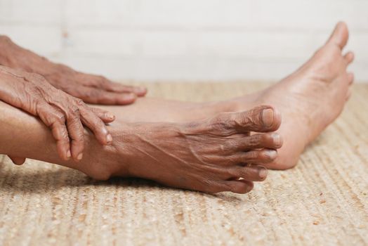 Close up on senior women feet and hand massage on injury spot