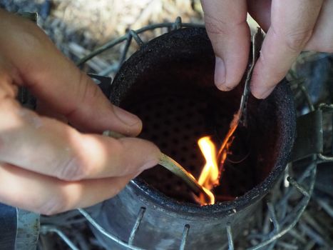 starting a bee smoker before harvesting honey hives in the farm.