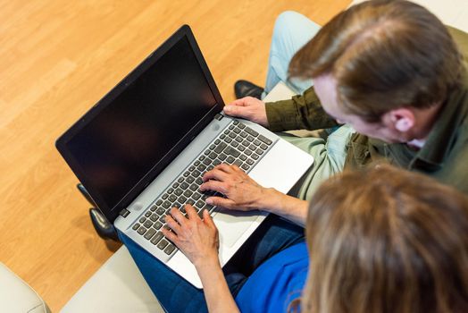 Mature man and woman in front of a laptop. Top view. High quality photo