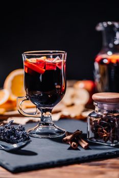 Still life - mulled wine, hot red wine with spices in glass among fruits. Scented cozy Christmas celebration, fragrant punch concept. High quality