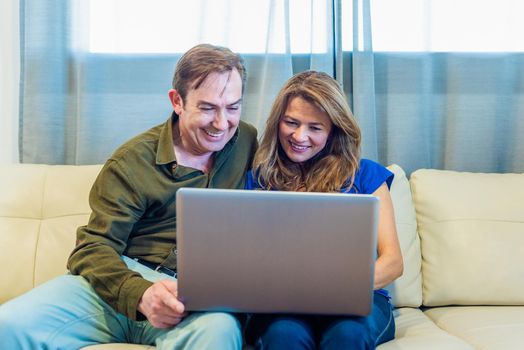 Smiling mature man and woman talking on video call with laptop. High quality photo