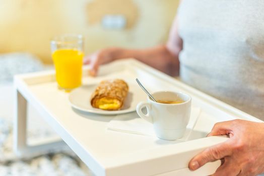 Detail of tray with breakfast held by a man. High quality photo