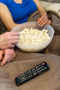 Popcorn bowl detail. Unrecognizable man and woman. High quality photo