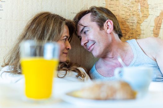 Mature couple in love in bed, with a tray with breakfast. High quality photo