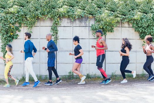 Group of runners training in a park. Side view.