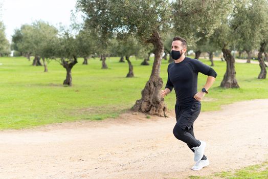 Runner with mask training in a park . High quality photo