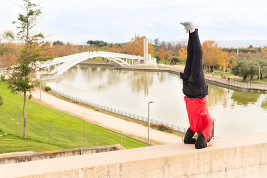 Man doing headstand exercise outdoors in a park. High quality photo