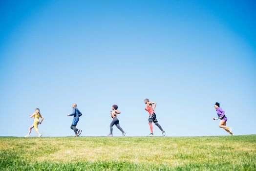 Group of runners training in a park. Side view.