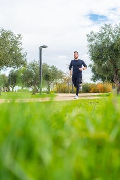 Runner with mask training in a park . High quality photo