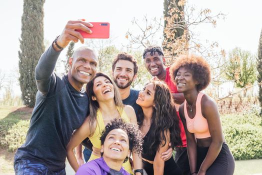 Group of runners taking a selfie in a park. Happy and smiling. Horizontal framing.