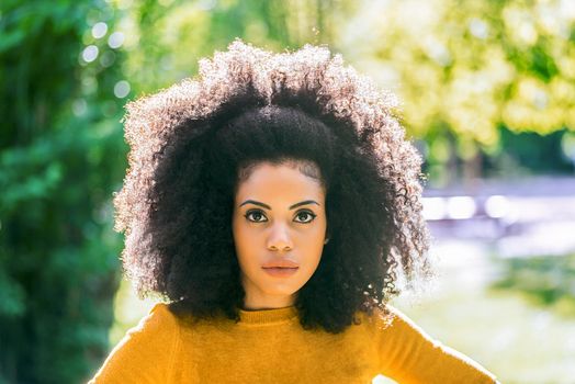 Portrait of nice afro girl in a garden. Close up. Selective focus.