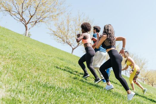 Group of runners running up a hill. Horizontal framing.