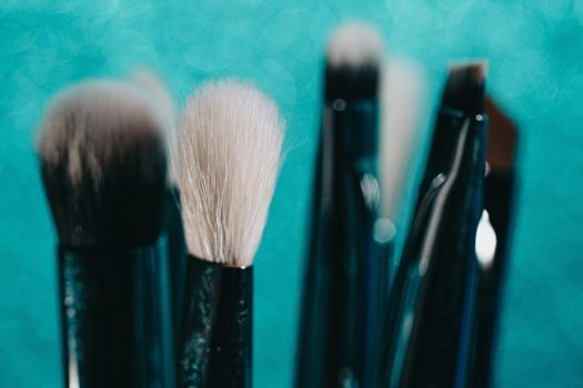 Cosmetics make-up brushes on blue sparkling background. High quality photo