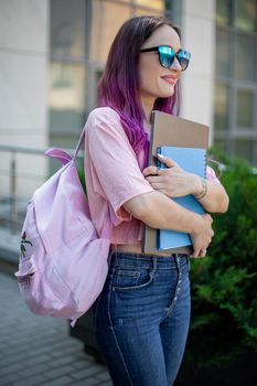 Portrait beautiful female writer dressed in casual outfit holding modern laptop in hand with backpack. Young student of faculty journalism having good mood outdoor