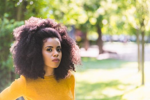 Portrait of nice afro girl in a garden. Close up. Selective focus.