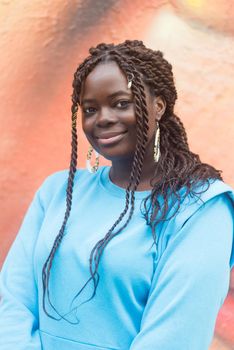 Pretty young black woman smiling at camera. Selective focus. Vertical framing.