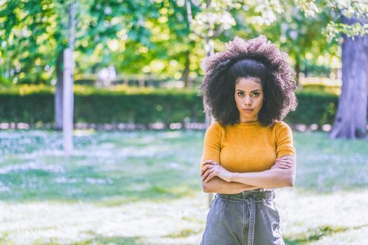 Portrait of nice afro girl in a garden. Mid shot. Selective focus.