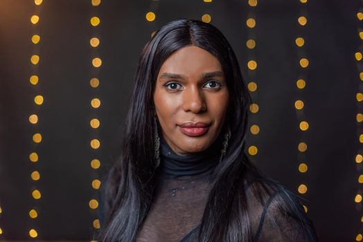Portrait of a transgender person looking at camera with a blurred light background with copy space