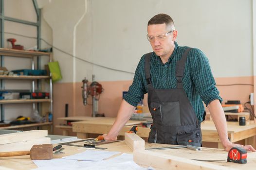 Portrait of a handsome male carpenter in the workshop