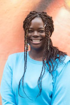 Pretty young black woman smiling at camera. Selective focus. Vertical framing.