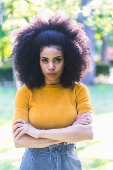 Portrait of nice afro girl in a garden. Mid shot. Selective focus.