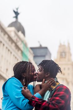 Black couple in love, in the city. Kissing. Selective focus.