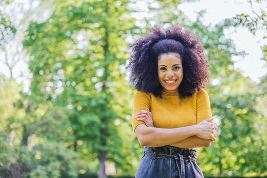 Portrait of nice afro girl in a garden. Mid shot. Selective focus.