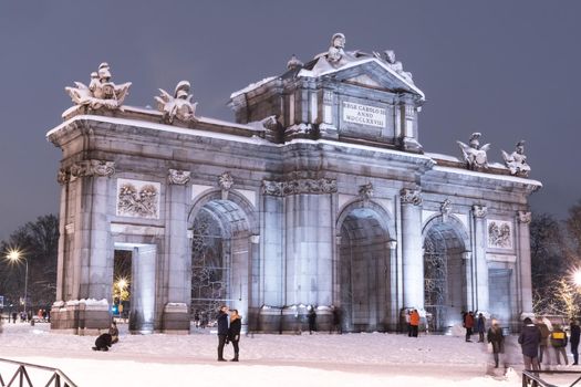 Puerta de Alcala in Madrid on a cold winter night after a heavy snowfall.