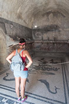 Woman with her back turned in the hot springs of the archaeological site of Herculaneum. Italy.