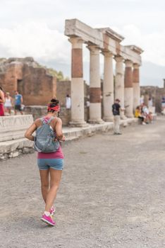 Woman walking through the Roman archaeological site of Pompeii, in Italy.