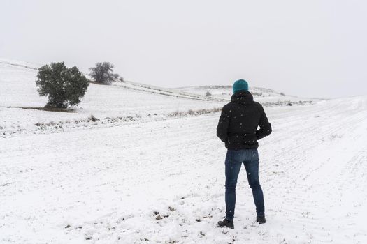 Person from behind in a snowy landscape. Madrid. Spain