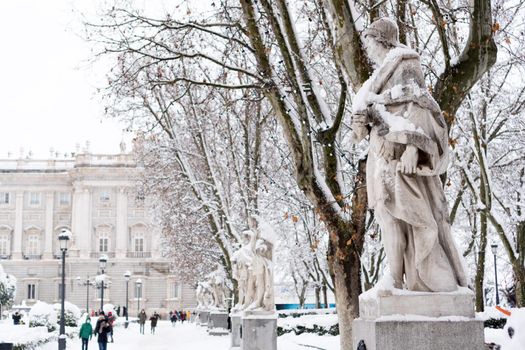 Statues covered by snow in the Plaza de Oriente in Madrid, on a cold winter day