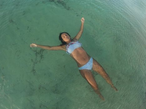 Woman floating face up in sea water, very relaxed. Formentera island. Spain.