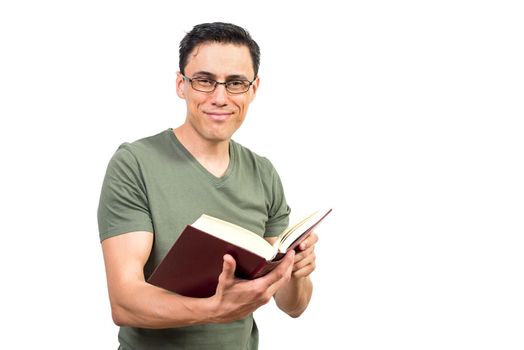 Optimistic clever male in glasses reading book while looking at camera on white isolated background