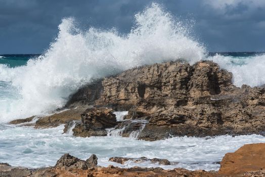 Seascape. Rough sea day with the waves crashing violently against the rocks on the shore. Formentera island, Spain.