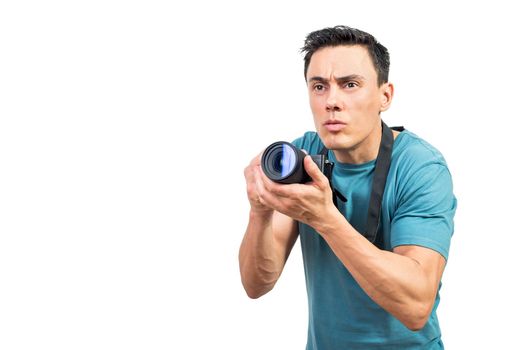 Concentrated male professional photographer taking photo on camera on white isolated background in studio