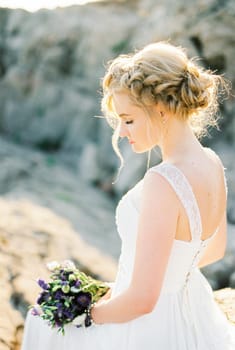 Bride in a white dress with a bouquet of flowers. Side view. High quality photo