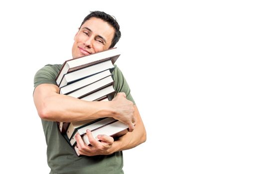 Glad male bookworm looking at camera with smile and hugging pile of good books before reading against white background