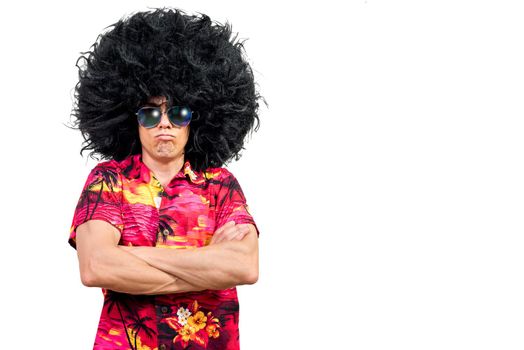 Funny male in vivid shirt with trendy sunglasses and Afro wig folding arms and pouting lips while being upset against white background