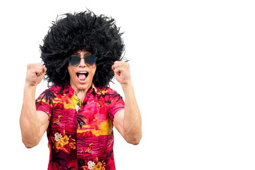 Excited male in funky Afro wig and stylish sunglasses clenching fists and screaming while celebrating success against white background