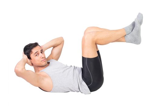 Full body of determined sportsman in activewear looking at camera while performing abdominal crunches isolated on white background during fitness workout
