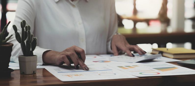 Businesswoman using calculator working at office with reports document financial..