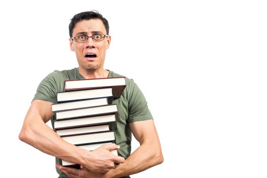 Terrified clever man in green t shirt and glasses embracing stack of books and looking at camera before exam against white background