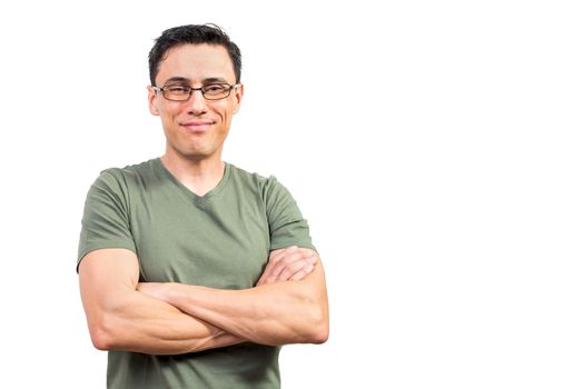 Self assured man in green t shirt and glasses crossing arms and looking at camera with smile against white background