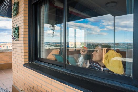 Man cleaning the windows at home. Full body.